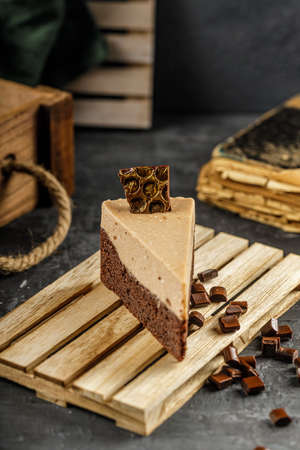 Still life of chestnut cake with chocolate mousse on a dark gray table with chocolate pieces.の写真素材