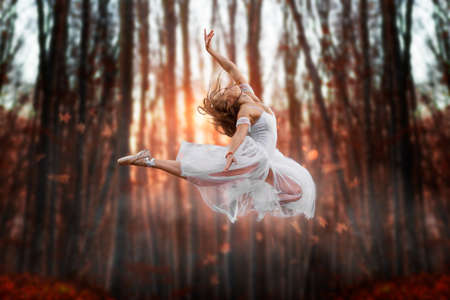 Flying attraction of a young beautiful ballerina. Attractive model in ballerine dress jumping up in...