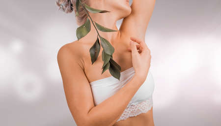 Beautiful woman body part with healthy skin. Young woman weared in white lingerie, isolated on light...