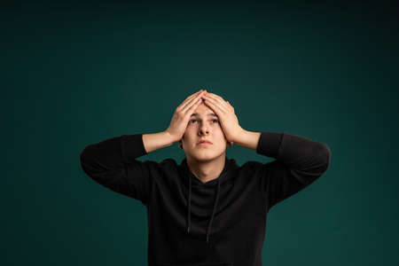 Regretful expression of a young man. Cropped studio portrait of male moodの写真素材