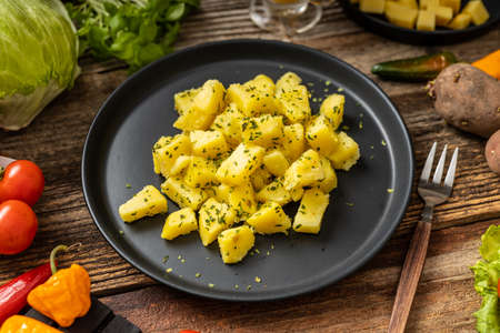 Tasty popatoes with persley served on black plateの写真素材