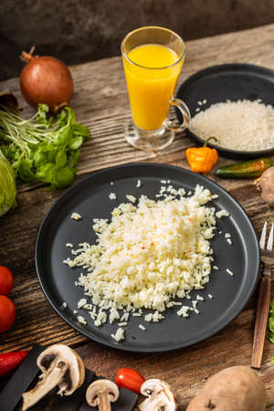 Rice garnish on black plate around vegetablesの写真素材