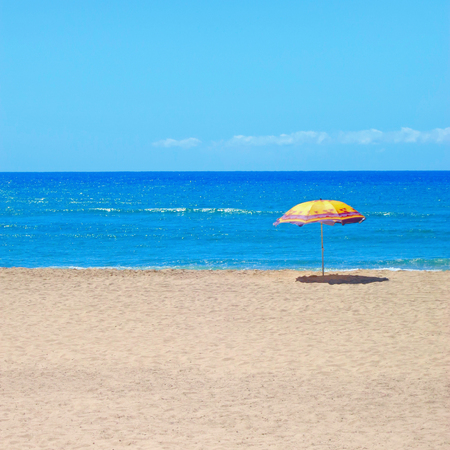White sandy beach, sea and blue sky with umbrellaの写真素材
