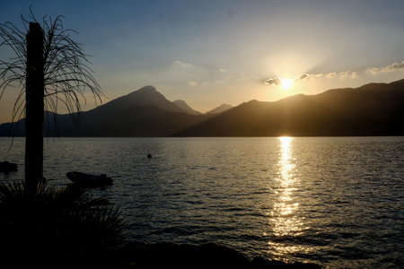 Sunset on Lake Garda, Italy. Beautiful view of the lake and mountains. Beautiful landscape in an evening mood by the water in the sunshine.の写真素材