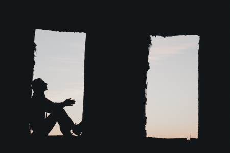 Man silhouette in the window above blue cloudy skyの写真素材