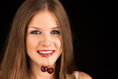 happy woman with cherries over whiteの写真素材