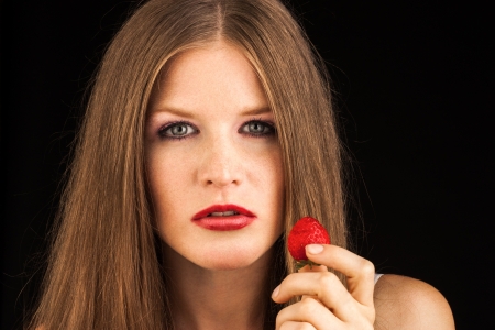 Young lady eating a strawberryの写真素材