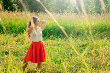 Portrait of young girl in a red skirt in parkの写真素材