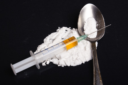 Drug syringe and cooked heroin on spoonの写真素材