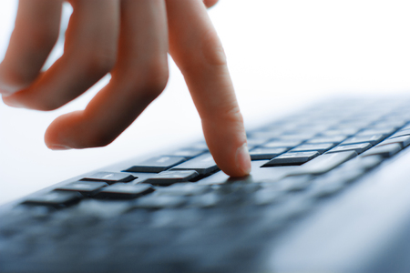 Male office worker typing on the keyboard. studio shotの写真素材