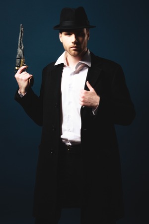 The man in style Chicago gangster with gun on dark backgroundの写真素材