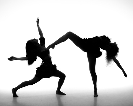 two women dance on a white background. studio shotの写真素材