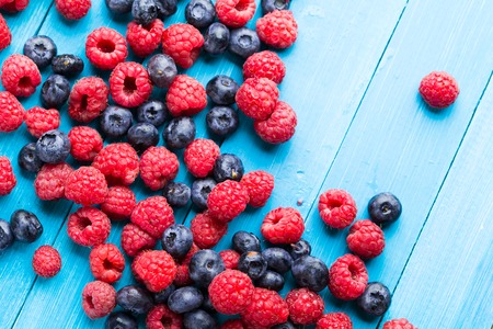 Summer berries on blue wooden background.の写真素材