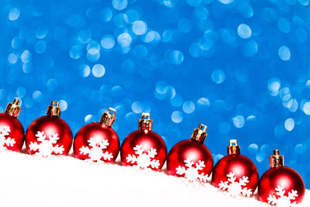christmas red balls in snow on blue glitter background. studio shotの写真素材