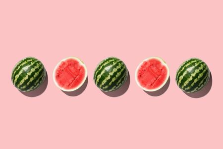 Row of fresh watermelon in center on pink backgrond. Top viewの写真素材