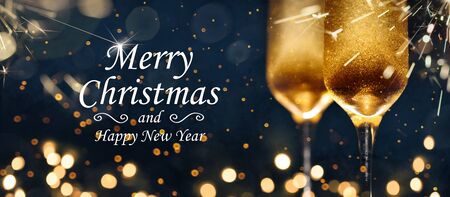 Two glasses of champagne with golden confetti, glitter, serpentine and lights.の写真素材