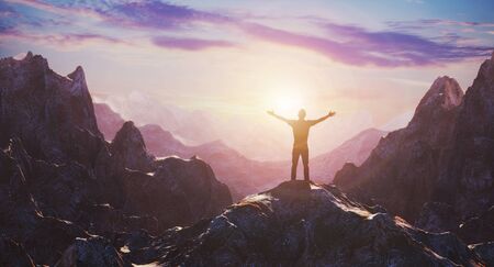 Hiker with arms up outstretched on mountain top looking at inspirational landscape. Inspiration and...
