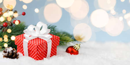 Christmas gift box, red ball with gold lights on blue backgroundの写真素材