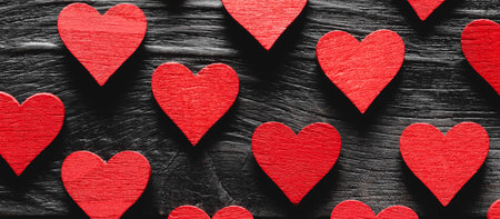 Red wooden hearts on a black wooden backgroundの写真素材