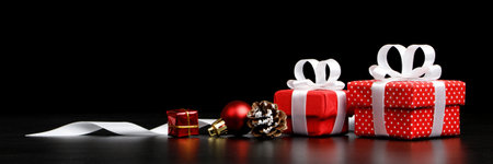 Two red gift with decorations isolated on black background. Christmas card