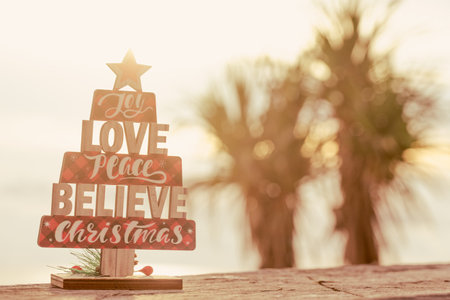 Christmas wooden toy tree on palms background.の写真素材