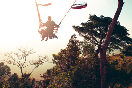 Man swinging on swing at the end of the world.