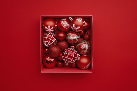 Red Christmas baubles decoration in the box on red background with copy spaceの写真素材