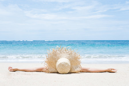 Woman lies on the white sand on the beach. summer and vacation conceptの写真素材