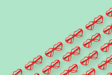 Pattern made with red heart shaped sunglasses on pastel color background. Valentine day concept.の写真素材