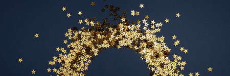 Round gold frame or border of random scatter golden stars, flat lay