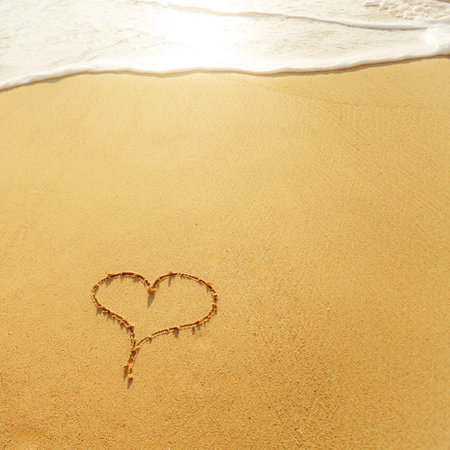 Heart on beach with sunset. Copy space.の写真素材