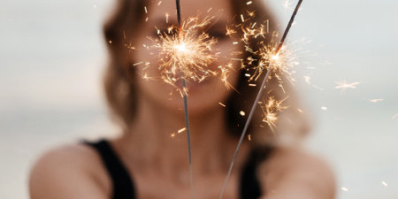 Beautiful smiling woman with sparklers on the beachの写真素材
