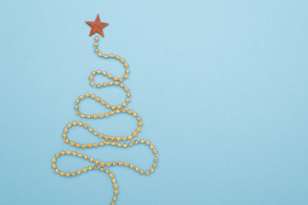 Christmas tree yellow garland on color background, flat layの写真素材