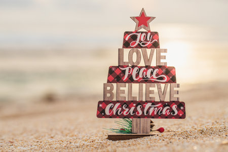 Wooden christmas tree toy on the beach. rustic styleの写真素材