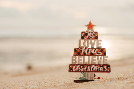 Wooden christmas tree toy on the beach. rustic styleの写真素材