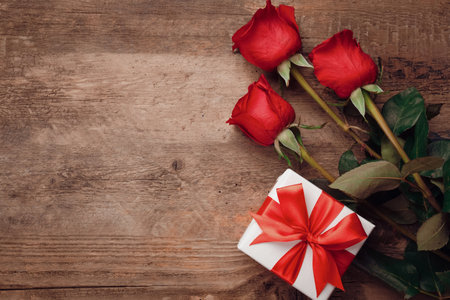 Valentine greeting card background with gift box and fresh burgundy roses.の写真素材