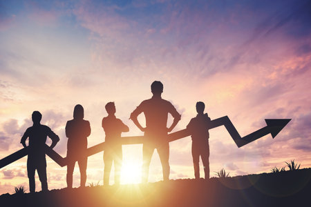 Team silhouette and up graph arrow on sunset background, leadership and teamwork conceptの写真素材