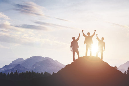 Silhouette of a team celebrating a victory against sunset background, concept of victory and...