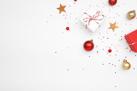 A bright white background adorned with beautiful red and gold Christmas decorations as well as a variety of colorful festive giftsの写真素材