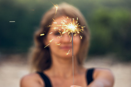 Beautiful woman with sparklers on the beachの写真素材
