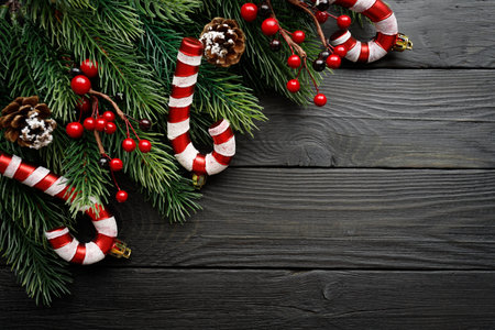 A cozy arrangement of fresh pine, colorful candy canes, and holiday elements on a rustic wooden backgroundの写真素材