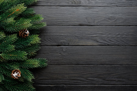 Closeup of beautiful pine branches with cones on dark wood, perfect for festive holiday themes and decorの写真素材