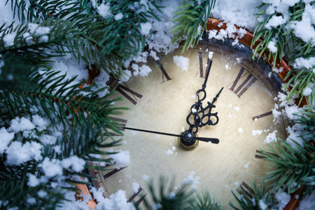cozy holiday scene with clock, snowdusted fir branches with festive clock and berries sceneの写真素材