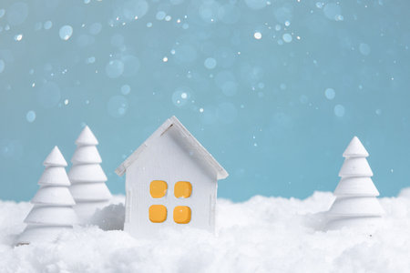 Cozy winter scene, Miniature house with snow, Tiny cozy house set against snowy landscape with warmの写真素材
