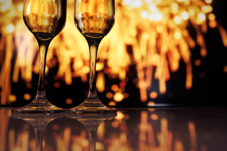 Fireworks illuminate victorious toast moment, Celebratory scene with champagne flutes and fireworksの写真素材