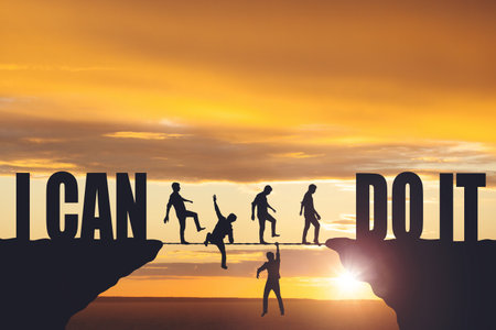 Silhouettes of people walking on a rope between rocksの写真素材