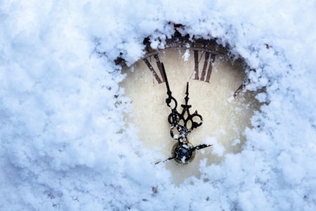 A clock with Roman numerals in the snow.の写真素材
