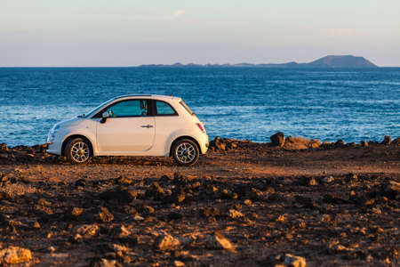 The white car in Lanzarote coast in front of Fuerteventura island.の写真素材