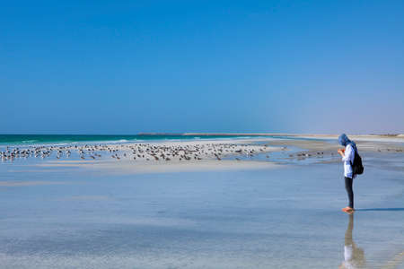 MIRBAT, OMAN - JANUARY 07,2016: A young girl is standing by the Indian Ocean coast near Mirbat, Oman.のeditorial素材