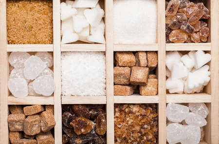 Various kinds of sugar in a wooden box. White refined, brown cane sugar collectionの写真素材